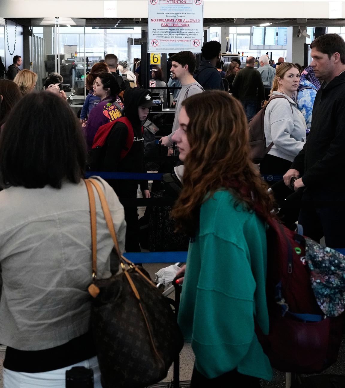 Reisende stehen an einem TSA-Kontrollpunkt am O'Hare International Airport in Chicago Schlange.