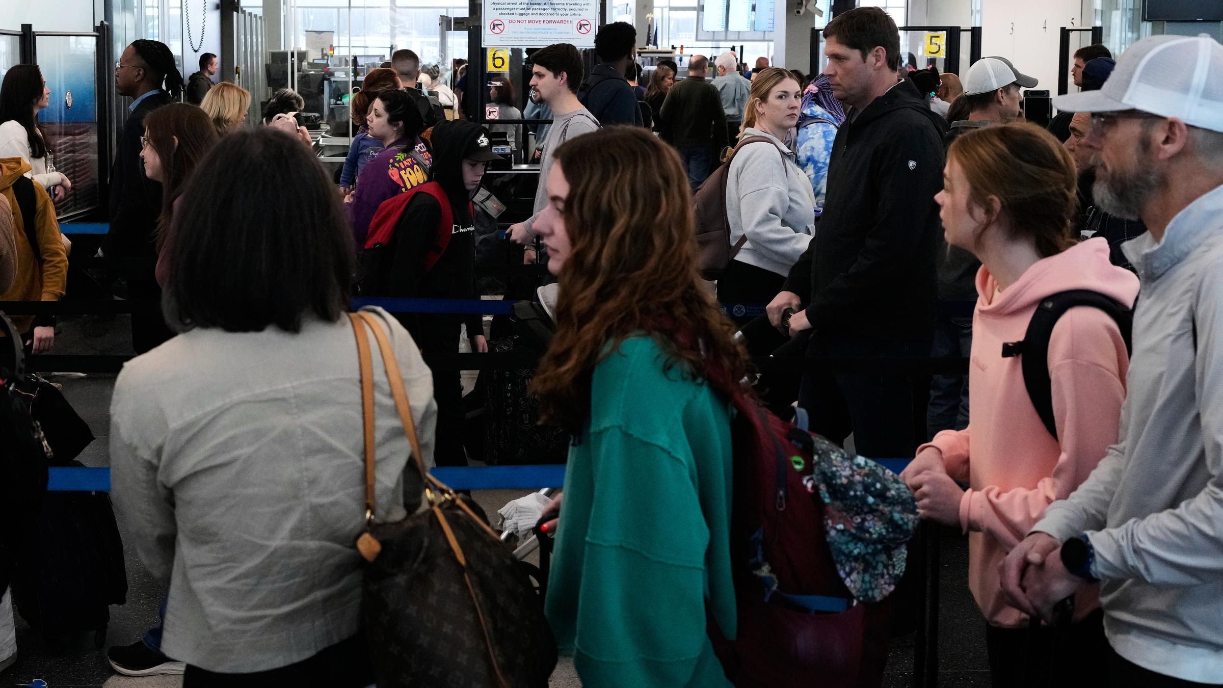 Reisende stehen an einem TSA-Kontrollpunkt am O'Hare International Airport in Chicago Schlange.