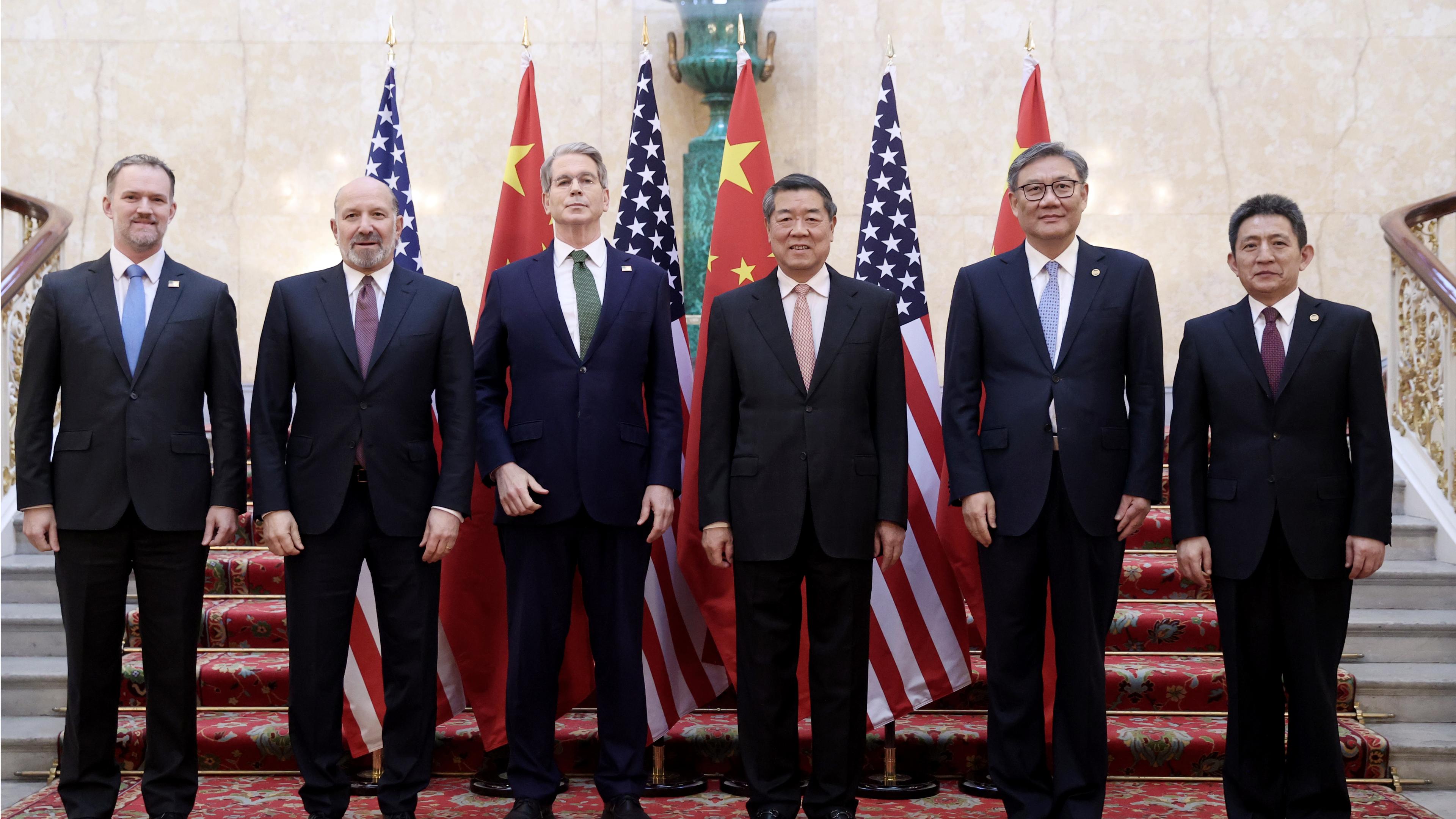 Jeweils 3 Vertreter beider Länder stehen nebeneinander vor den Flaggen der USA und Chinas.