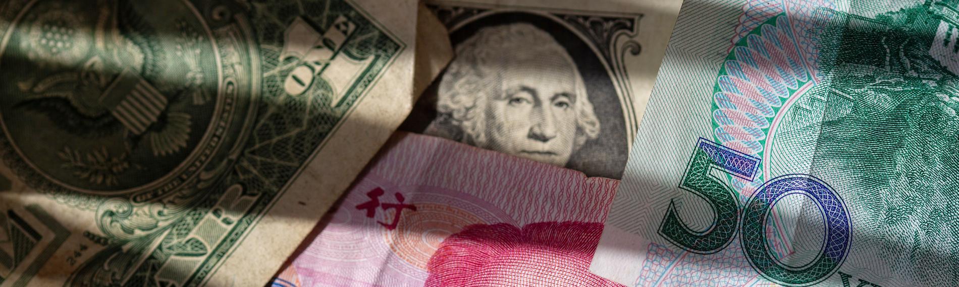 Chinesische Yuan-Banknoten liegen zwischen mehreren US-Dollar-Scheinen.