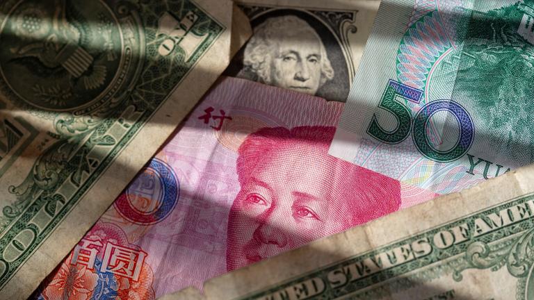 Chinesische Yuan-Banknoten liegen zwischen mehreren US-Dollar-Scheinen.