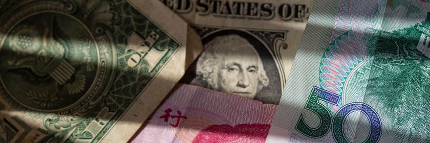 Chinesische Yuan-Banknoten liegen zwischen mehreren US-Dollar-Scheinen.