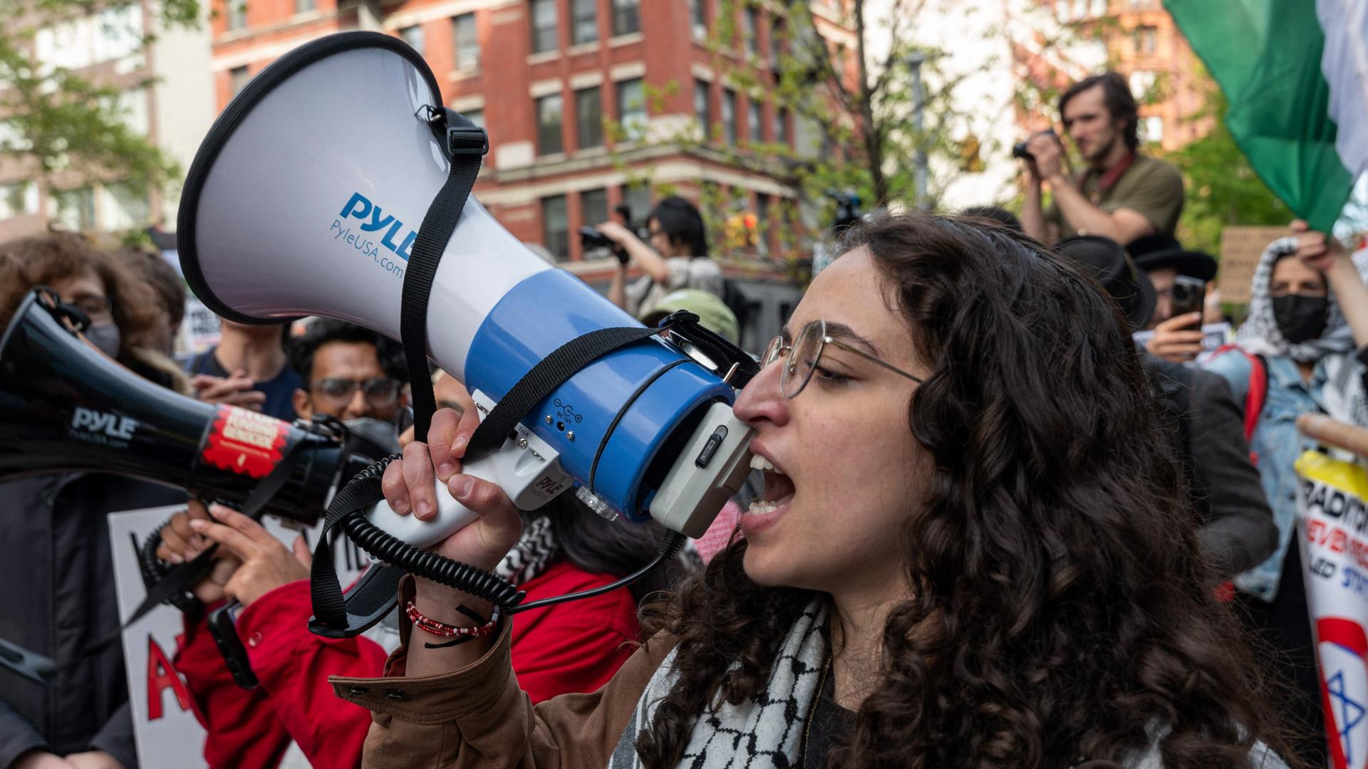 Eine junge Frau mit Megafon bei einer Gaza-Demo.