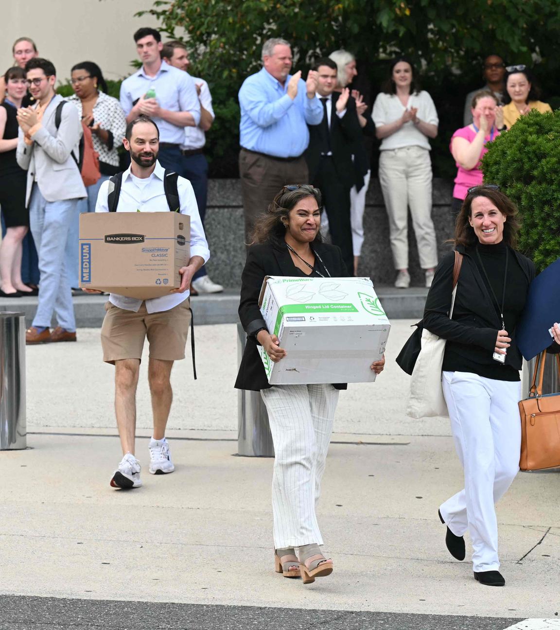 Von der US-Regierung entlassene Angestellte tragen ihre Sachen aus einem Gebäude in Washington DC.