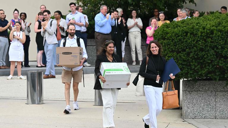 Von der US-Regierung entlassene Angestellte tragen ihre Sachen aus einem Gebäude in Washington DC.