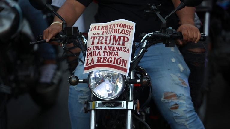 Auf einer Motorrad-Demonstration in Caracas, Venzuela, steht auf einem Schild: "Achtung an alle Leute: Trump ist eine Gefahr für die ganze Region."