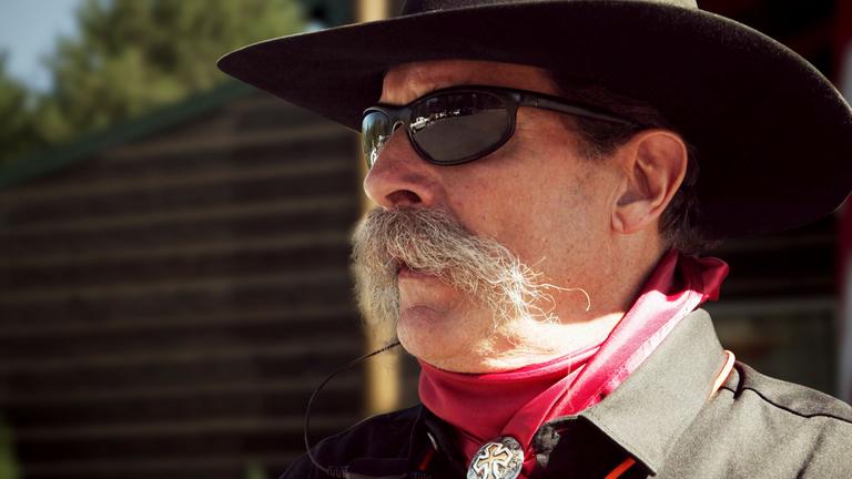 Clyde Tinley, der Mitglied in der "North Idaho Miliz", im Profil im Cowboy-Look mit Sonnenbrille.