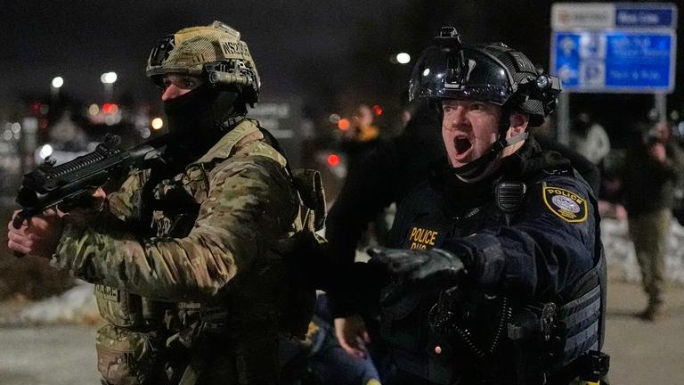 Bundesbeamte der Einwanderungsbehörde konfrontieren Demonstranten vor dem Bishop Henry Whipple Federal Building in Minneapolis.