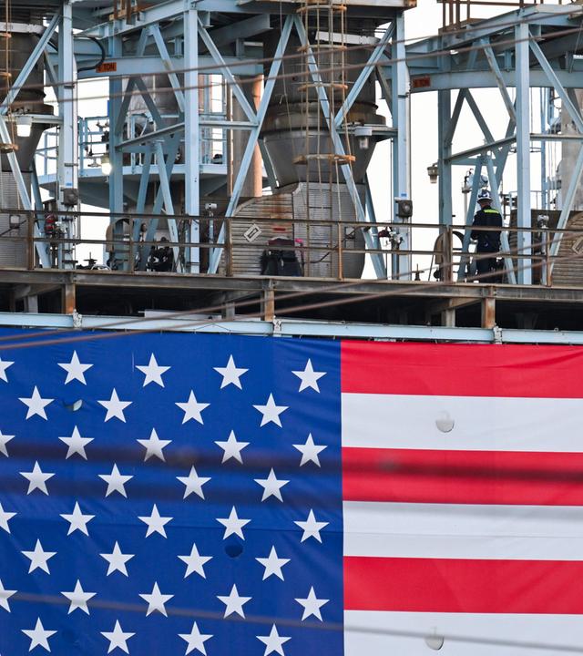 Ein Arbeiter geht an einer US-Flagge vorbei, die vor der Raffinerie der Marathon Petroleum Corp. in Carson, Kalifornien, angebracht ist.