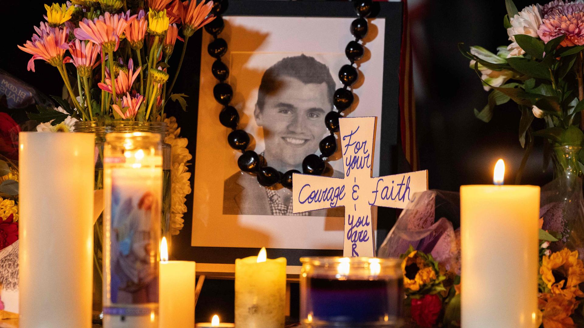Menschen gedenken dem ermordeten Charlie Kirk mit Blumen, Kerzen und einen Portrait des US-Aktivisten.
