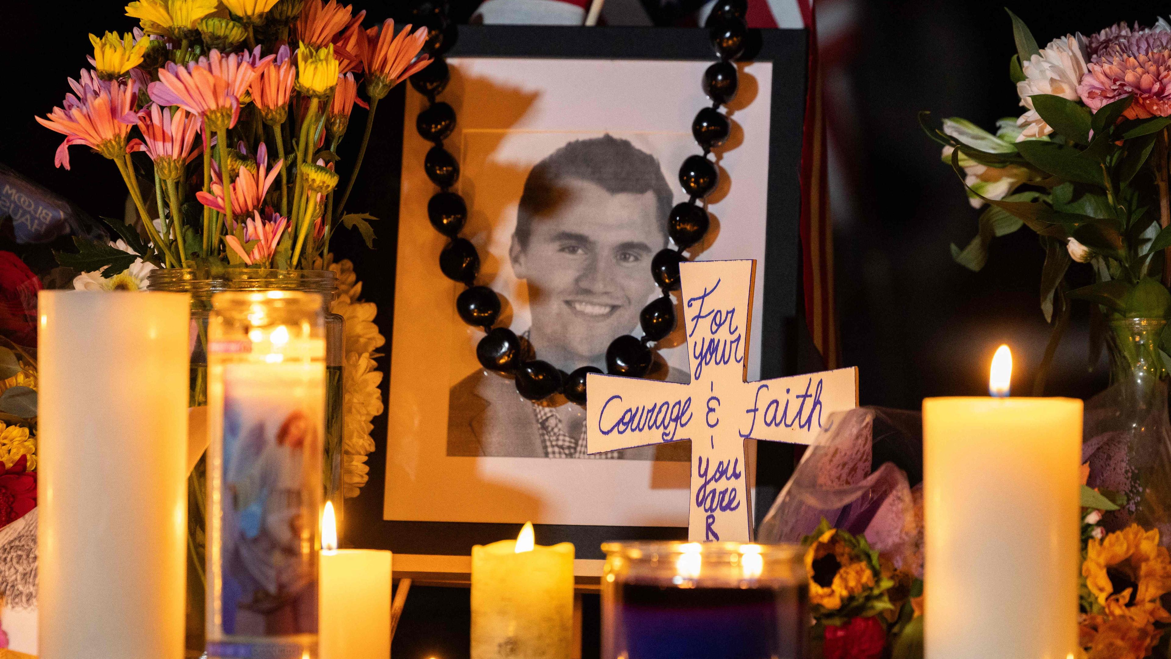 Menschen gedenken dem ermordeten Charlie Kirk mit Blumen, Kerzen und einen Portrait des US-Aktivisten.