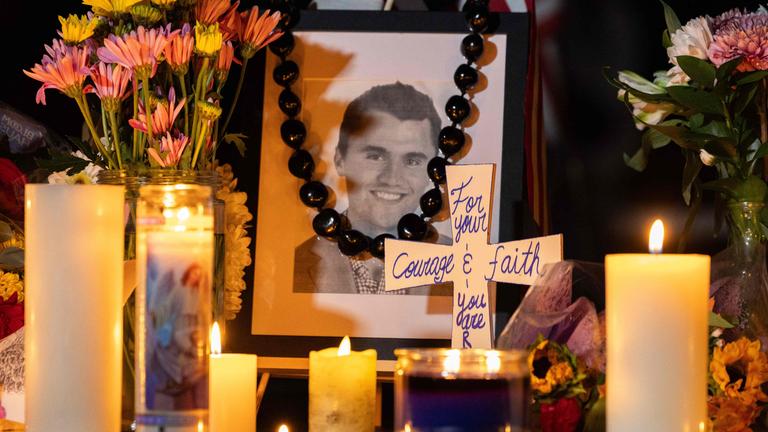 Menschen gedenken dem ermordeten Charlie Kirk mit Blumen, Kerzen und einen Portrait des US-Aktivisten.