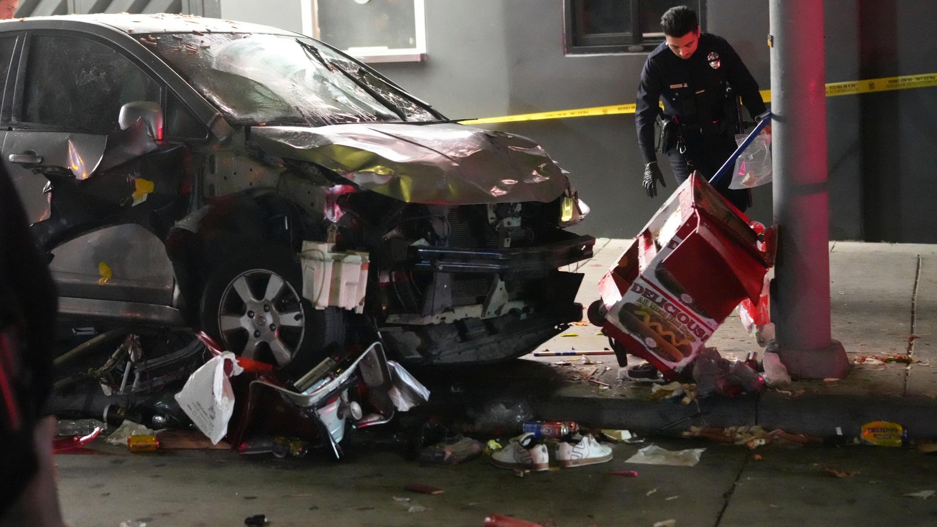 USA, Los Angeles: Beschödigtes Auto wird von der Polizei untersucht nachdem es in eine Menschenmenge gerast ist