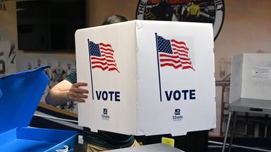 Ein Wahlhelfer richtet für die Midterms 2026 Wahlkabinen in einem Wahllokal ein.