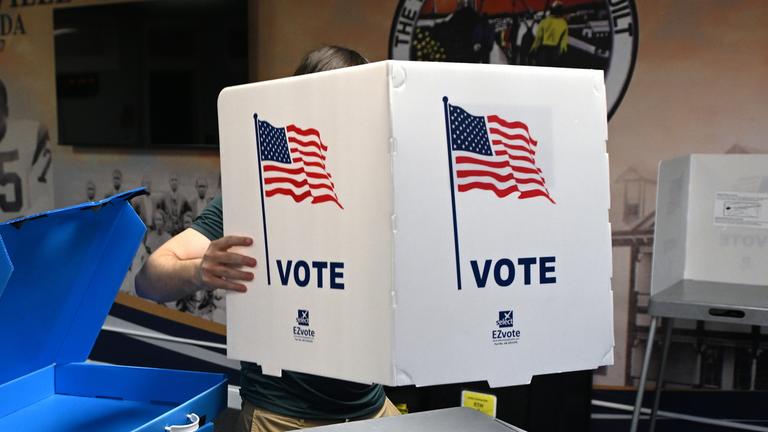 Ein Wahlhelfer richtet für die Midterms 2026 Wahlkabinen in einem Wahllokal ein.