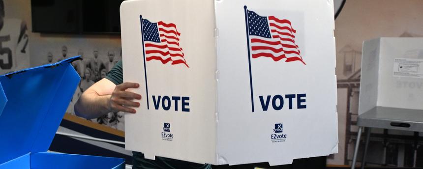 Ein Wahlhelfer richtet für die Midterms 2026 Wahlkabinen in einem Wahllokal ein.