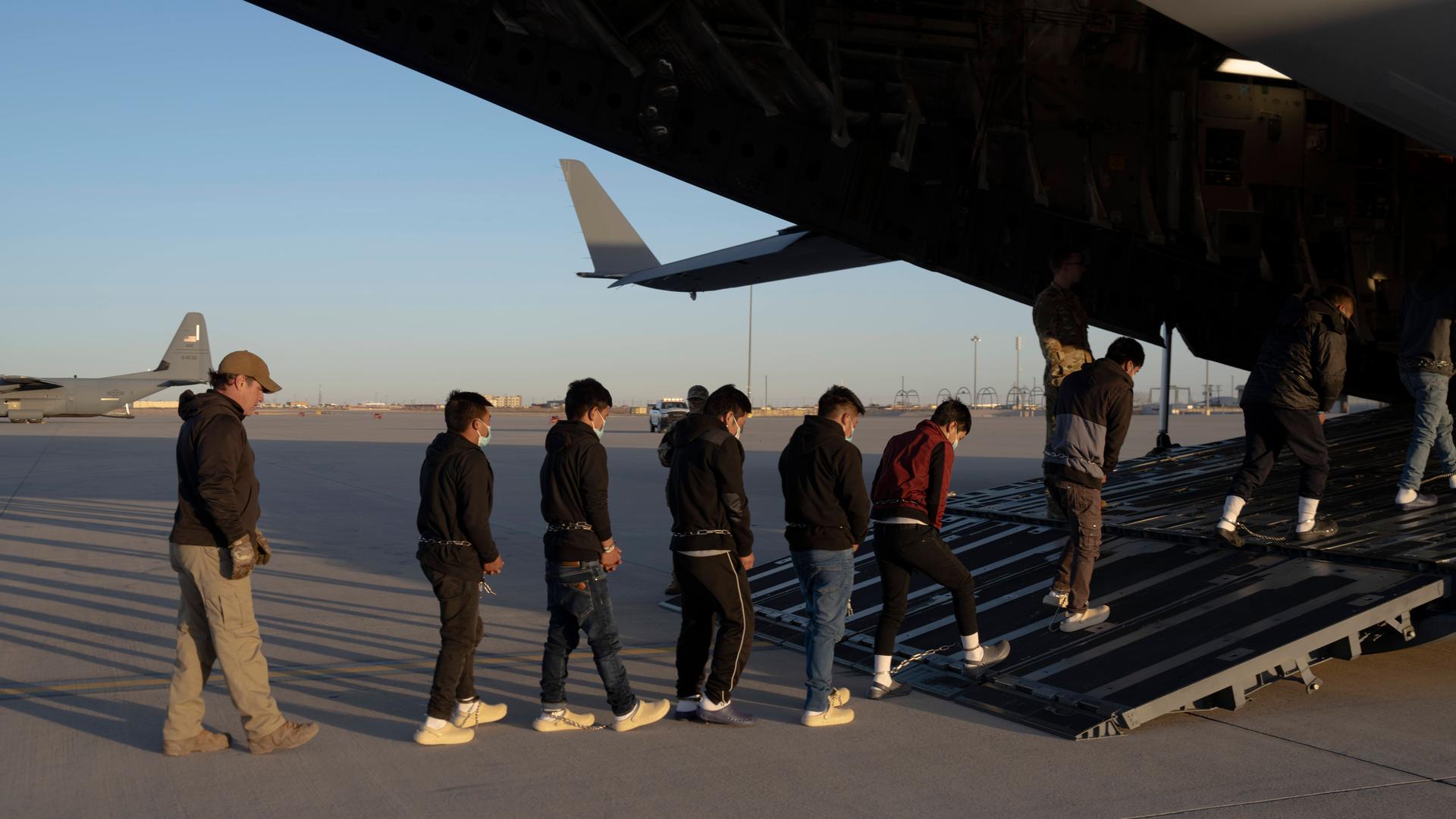 US-Grenzschutzbeamte führen Migranten ohne Papiere in ein Transportflugzeug der US-Luftwaffe für einen Abschiebeflug nach Guatemala