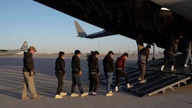 US-Grenzschutzbeamte führen Migranten ohne Papiere in ein Transportflugzeug der US-Luftwaffe für einen Abschiebeflug nach Guatemala