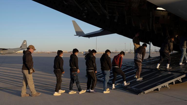 US-Grenzschutzbeamte führen Migranten ohne Papiere in ein Transportflugzeug der US-Luftwaffe für einen Abschiebeflug nach Guatemala