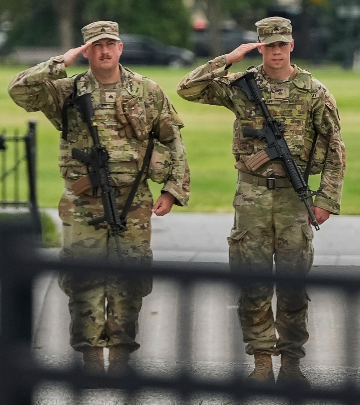  Soldaten der Nationalgarde salutieren, als die Wagenkolonne von Präsident Donald Trump , in Washington vorbeifährt. 