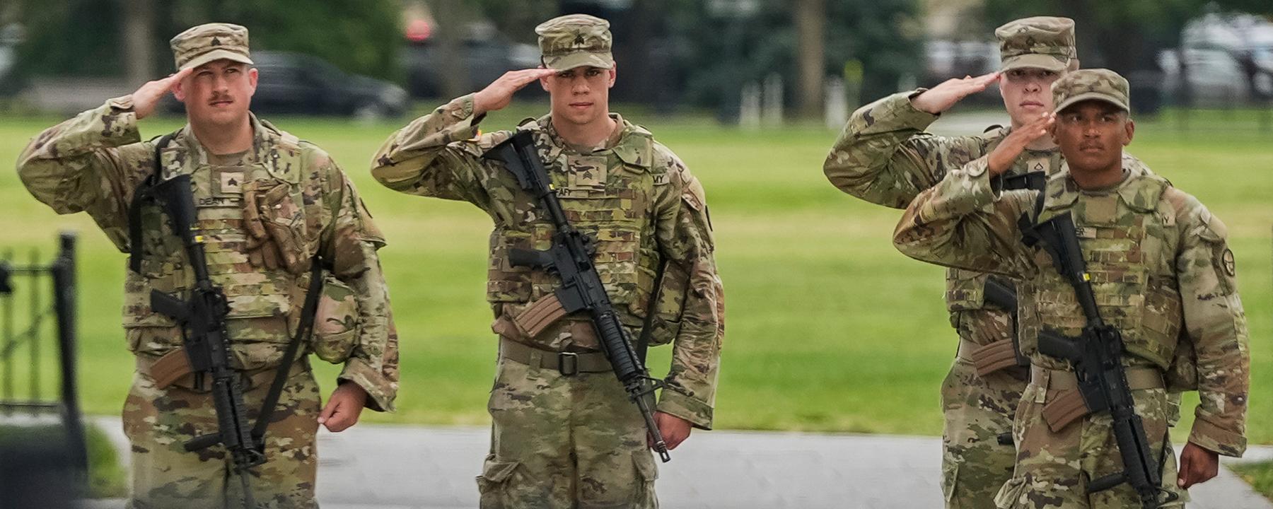  Soldaten der Nationalgarde salutieren, als die Wagenkolonne von Präsident Donald Trump , in Washington vorbeifährt. 