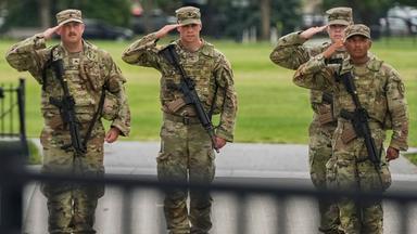  Soldaten der Nationalgarde salutieren, als die Wagenkolonne von Präsident Donald Trump , in Washington vorbeifährt. 