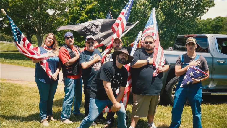 Eine Gruppe Rednecks schwenkt US-Flaggen.