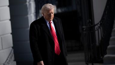 US-Präsident Trump im schwarzen Anzug, mit roter Krawatte.