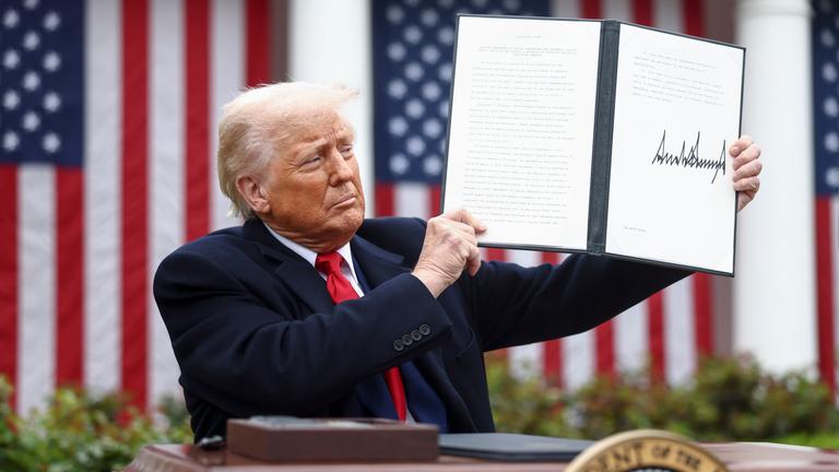 US-Präsident Trump hält seine Unterschrift hoch