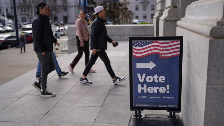 Wähler betreten ein Wahllokal. 