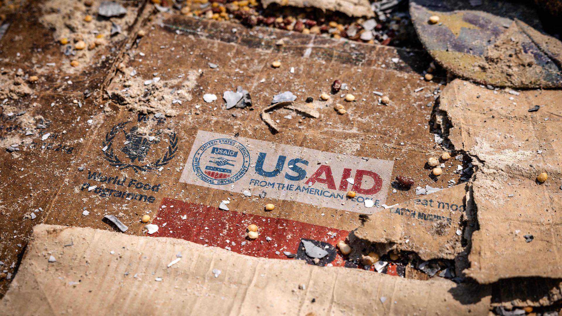Ein USAID-Logo ist auf einer Kiste inmitten der verstreuten Überreste von Kisten und Materialien zu sehen