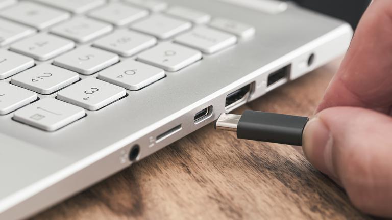 Ein USB-Typ-C-Stecker wird in einen Laptop eingesteckt.