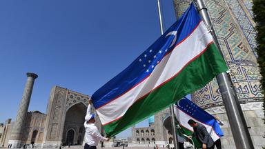 Ein Polizist hält Wache vor einer Aufschrift mit Samarkand in Usbekistan von dem EU-Zentralasien-Gipfel am 3.04.2025.