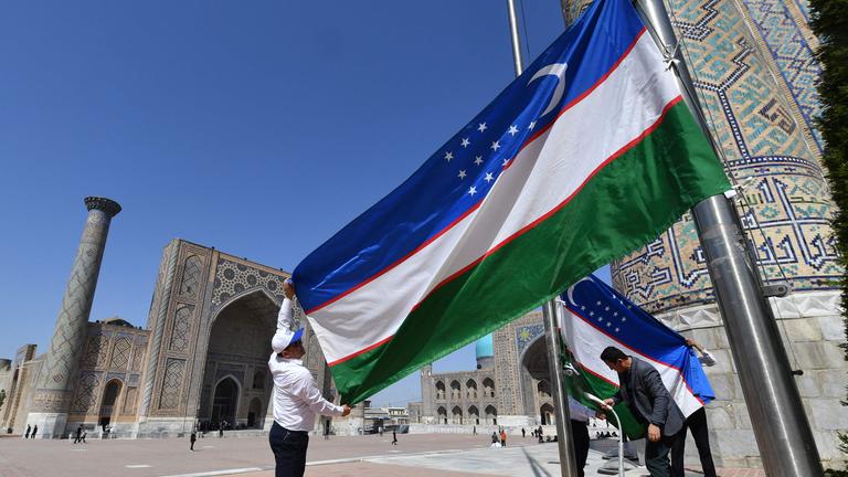 Ein Polizist hält Wache vor einer Aufschrift mit Samarkand in Usbekistan von dem EU-Zentralasien-Gipfel am 3.04.2025.