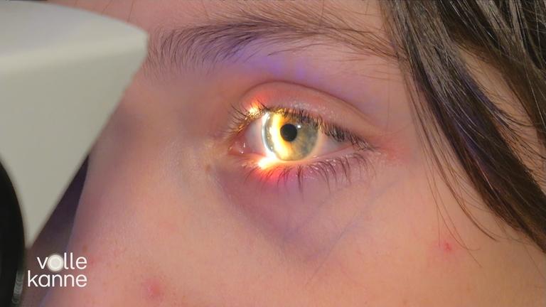 Junge wird mit einem Licht bei einer Untersuchung ins Auge geleuchtet.