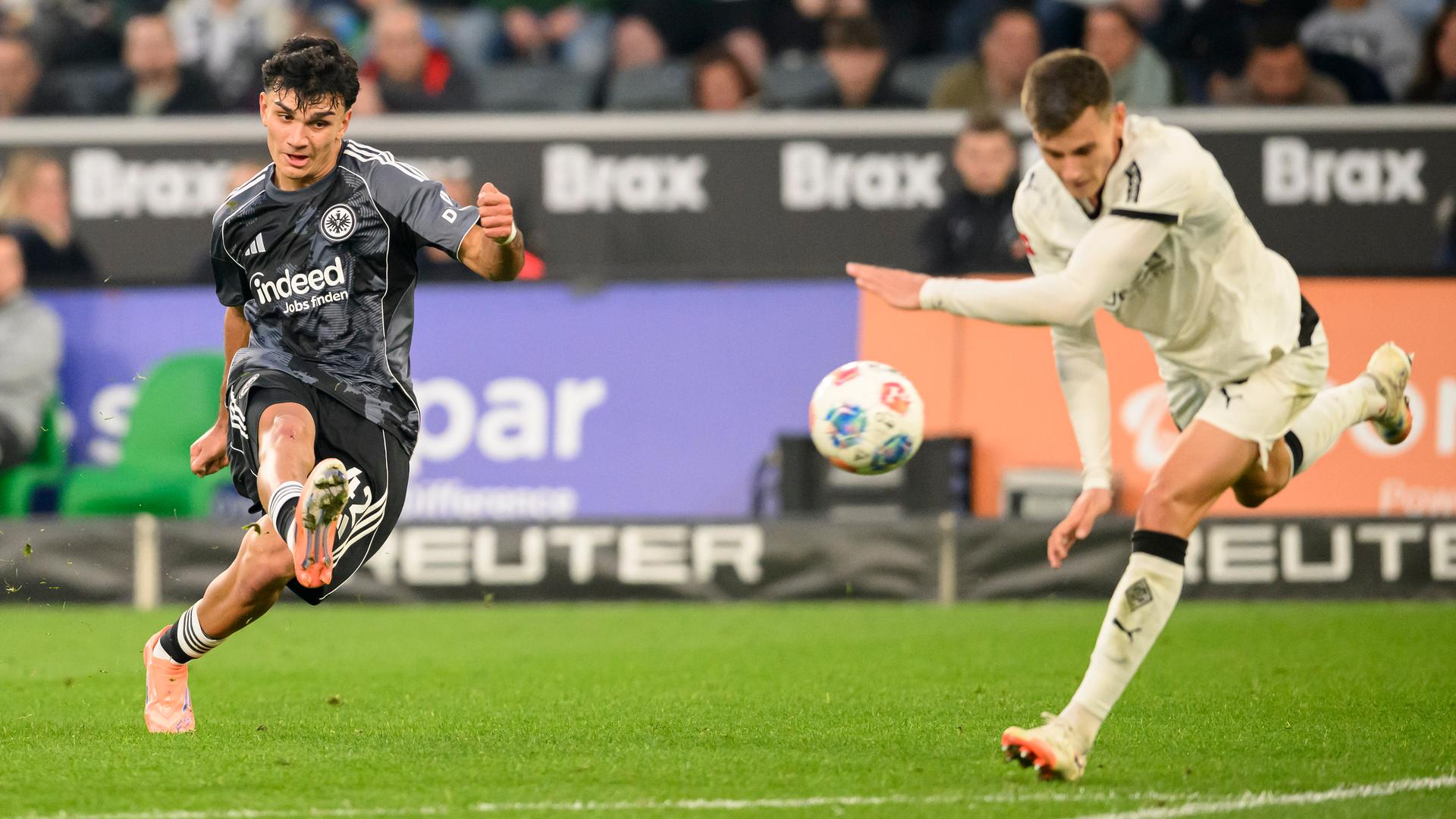 Can Uzun (Eintracht Frankfurt) beim Torschuss. Gladbachs Yannik Engelhardt (rechts) kommt zu spät