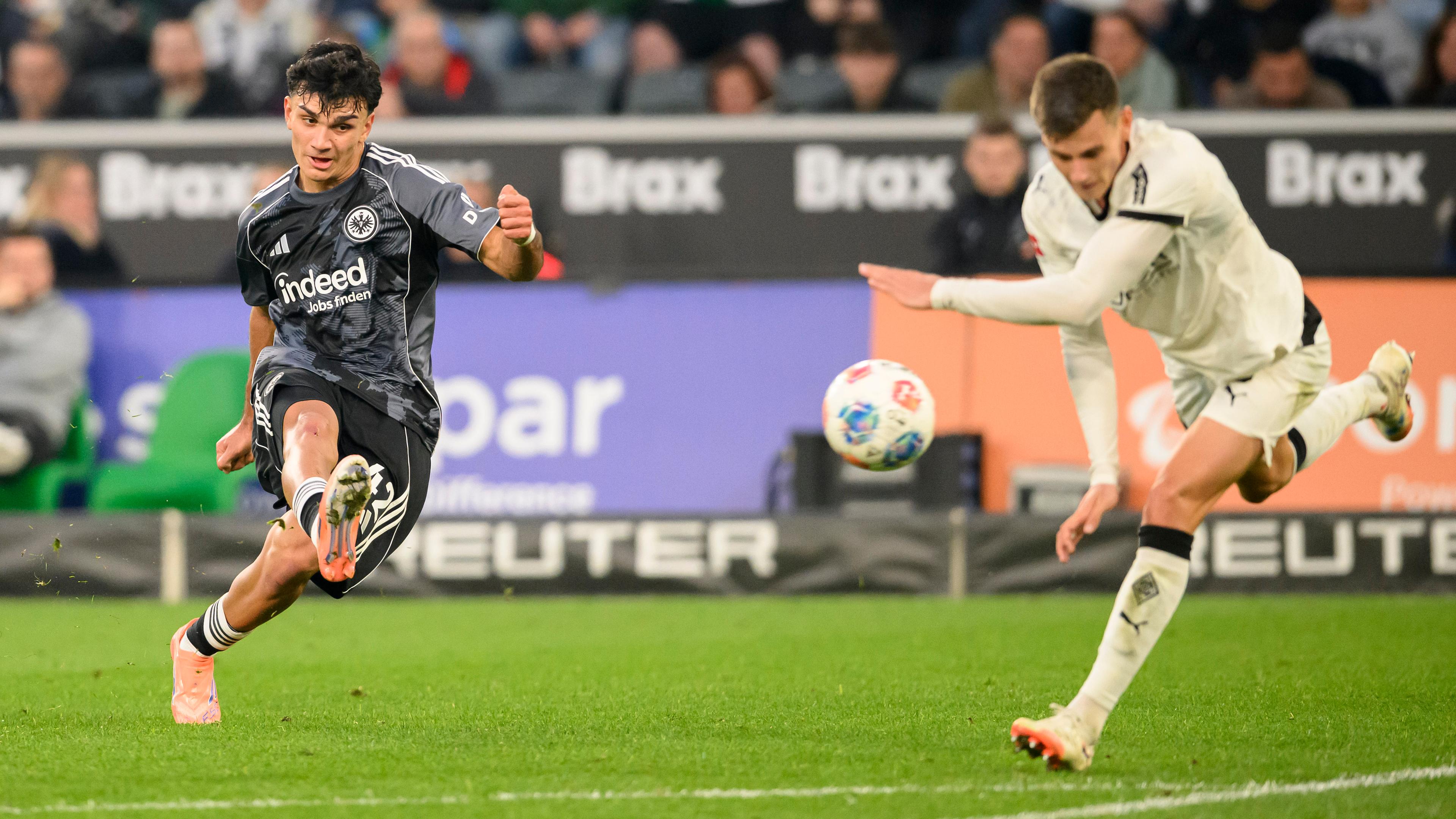 Can Uzun (Eintracht Frankfurt) beim Torschuss. Gladbachs Yannik Engelhardt (rechts) kommt zu spät