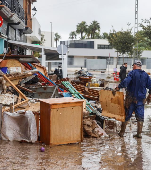 Menschen stapeln Möbel, die nach den durch heftige Regenfälle verursachten Überschwemmungen aus den Häusern geräumt werden mussten.