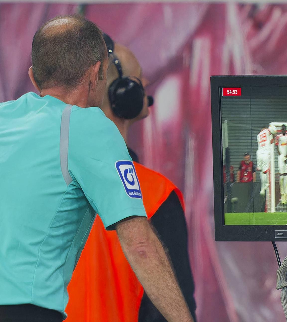 Schiedsriuchter schaut sich eine Szene auf dem Monitor ab