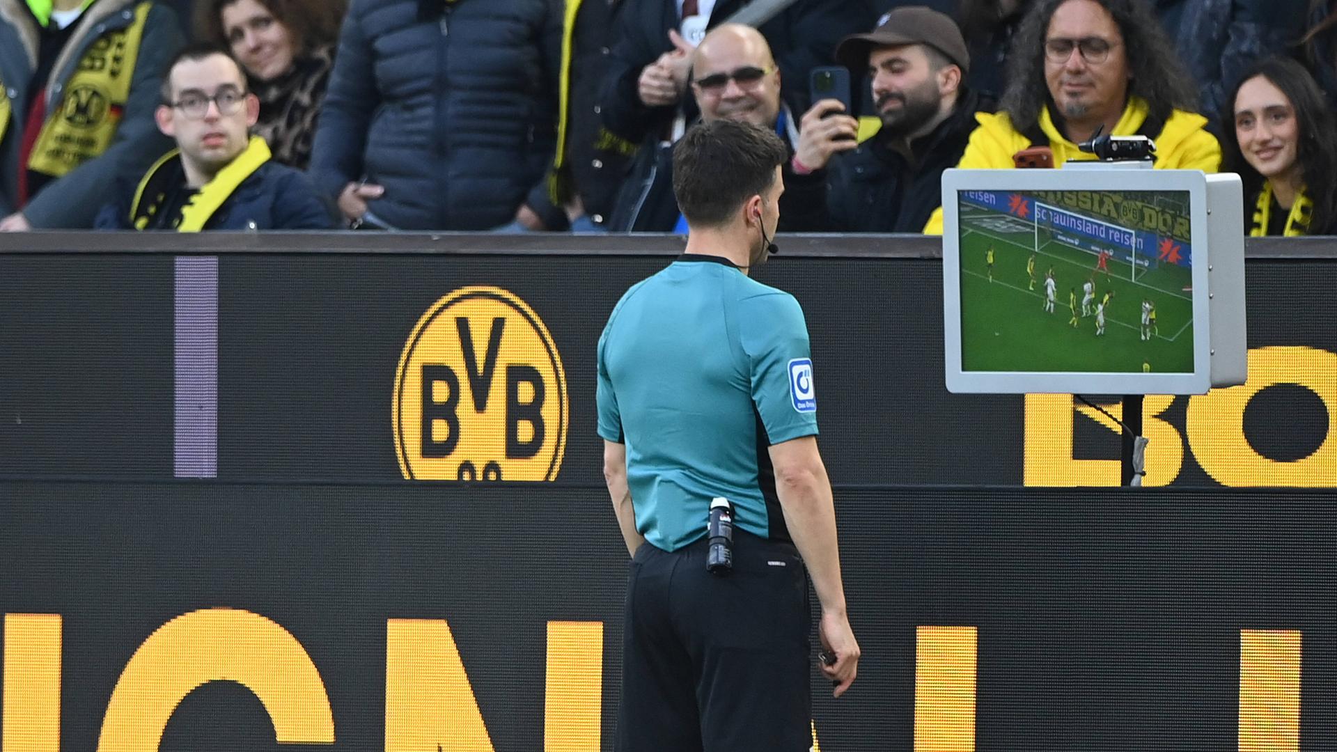 Fußball: Schiedsrichter Osmers prüft die Videobilder.