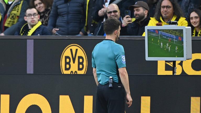 Fußball: Schiedsrichter Osmers prüft die Videobilder.