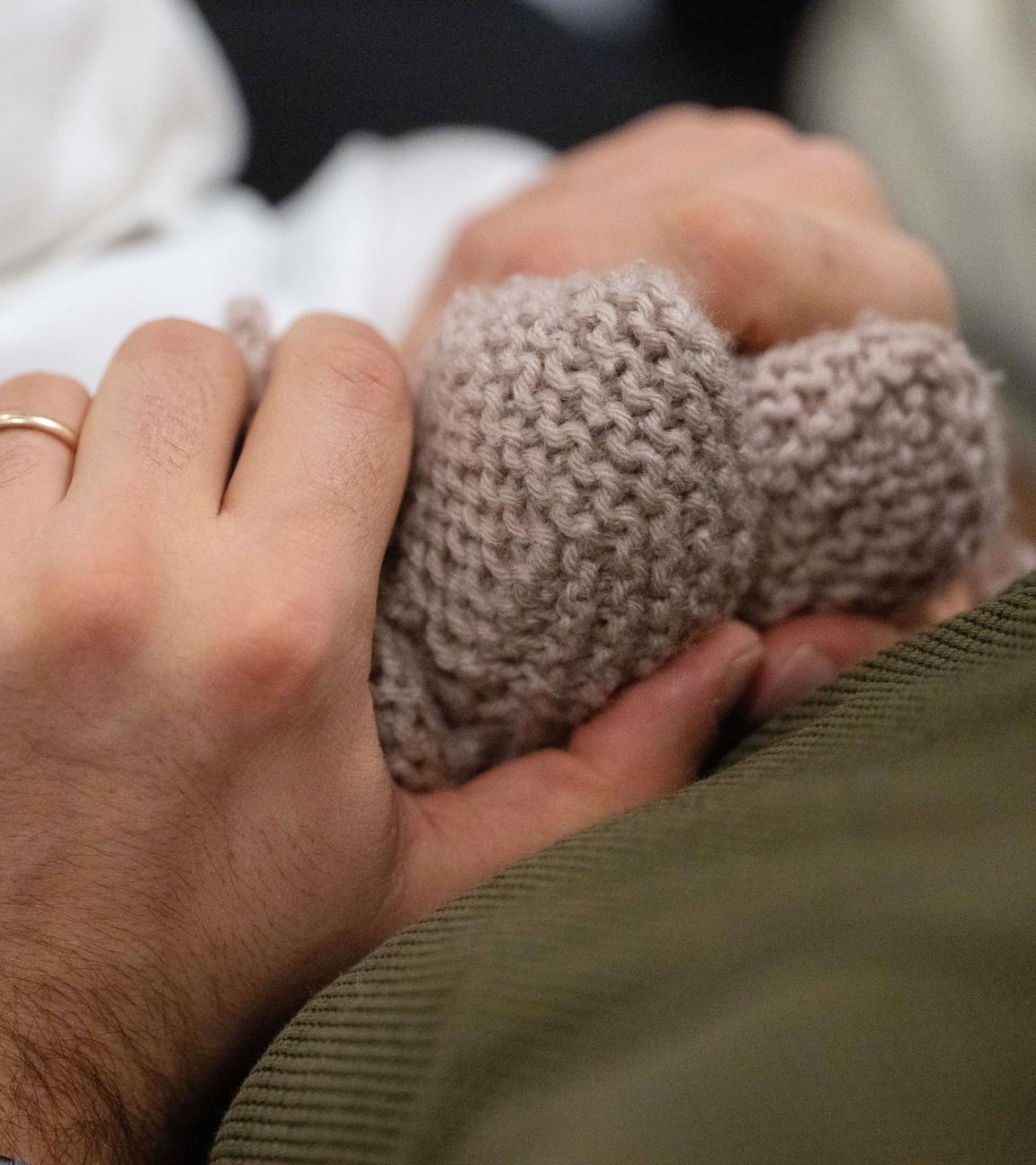 Baden-Württemberg, Stuttgart: Ein Vater hält während eines Infant Handling Kurses die Füße seines Kindes.