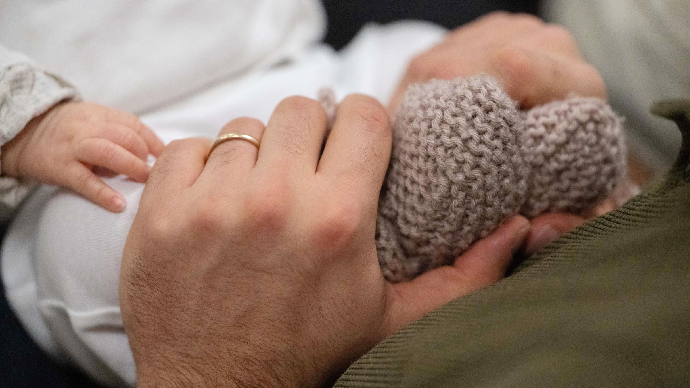 Baden-Württemberg, Stuttgart: Ein Vater hält während eines Infant Handling Kurses die Füße seines Kindes.