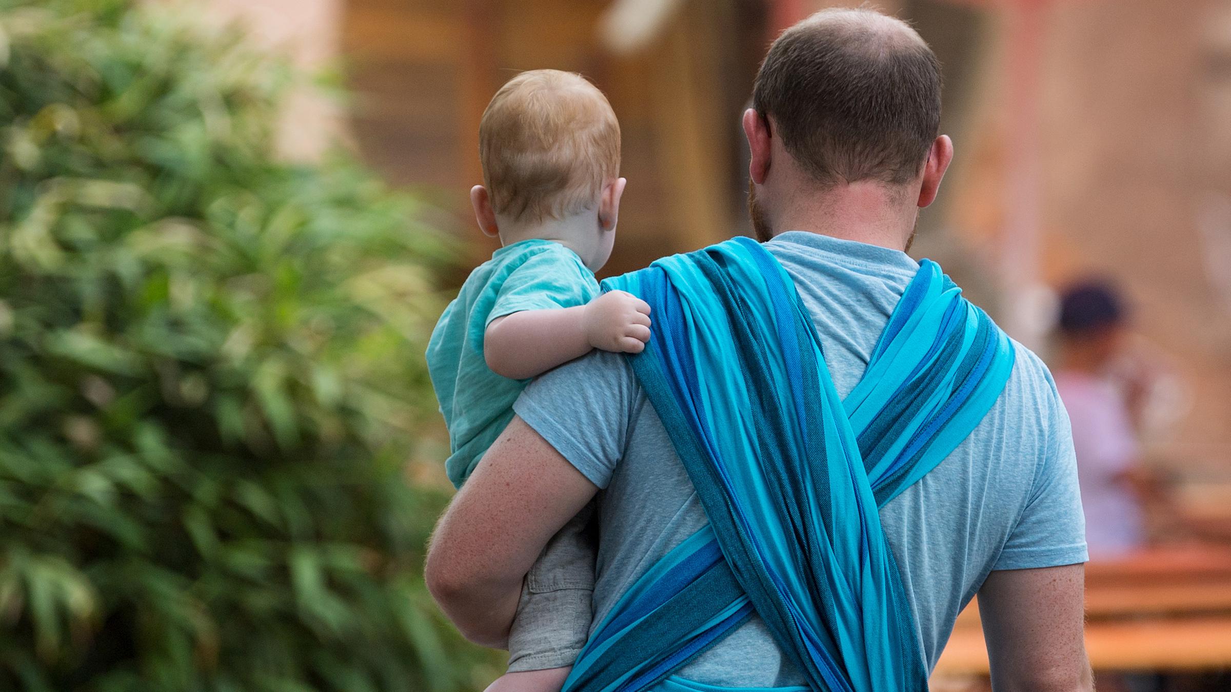 Ein Mann hält ein Baby auf dem Arm 