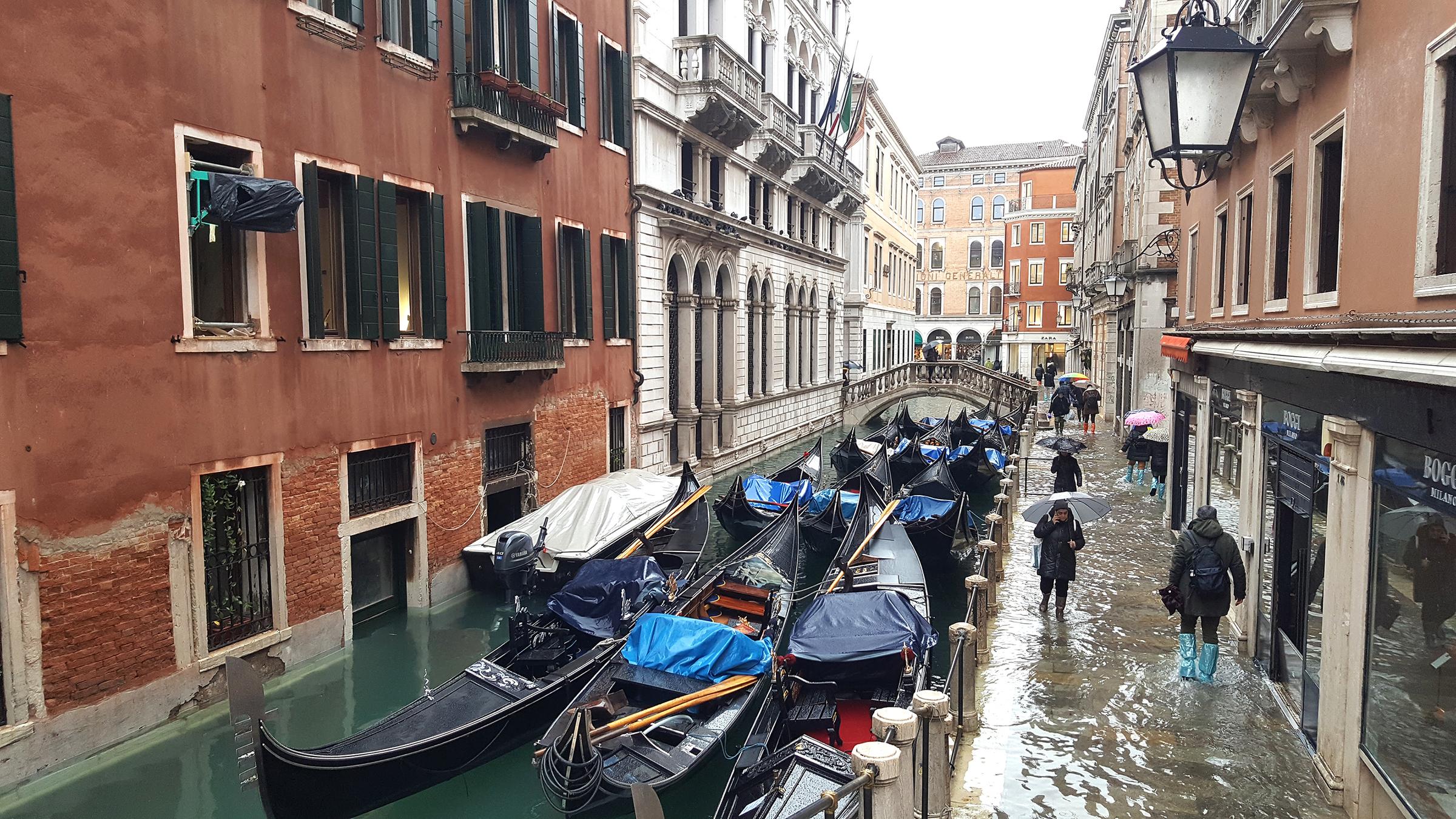 Boote und Gondeln in einem Kanal in Venedig.