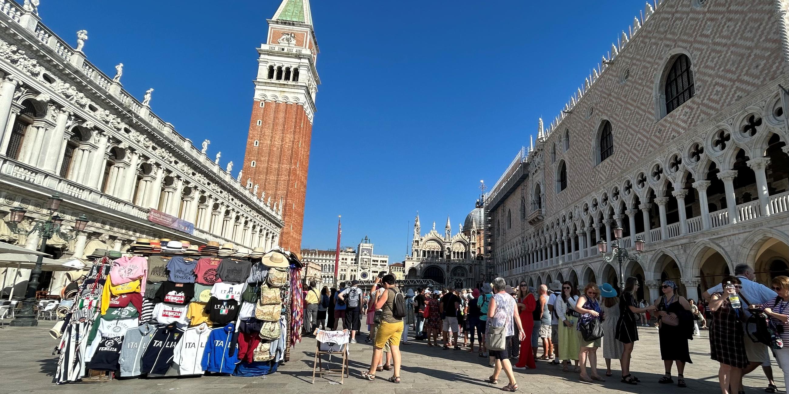 Venedig: Touristen stehen auf dem Markusplatz mit Campanile (M.) und Dogenpalast (r.)
