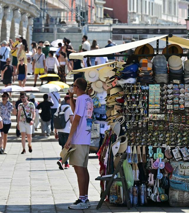 Ein Straßenverkäufer trinkt während einer Hitzewelle am 27. Juni in Venedig Wasser.