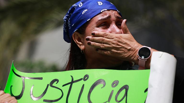 Eine Frau weint und fordert auf einem Plakat "Justicia" (dt.: Gerechtigkeit).