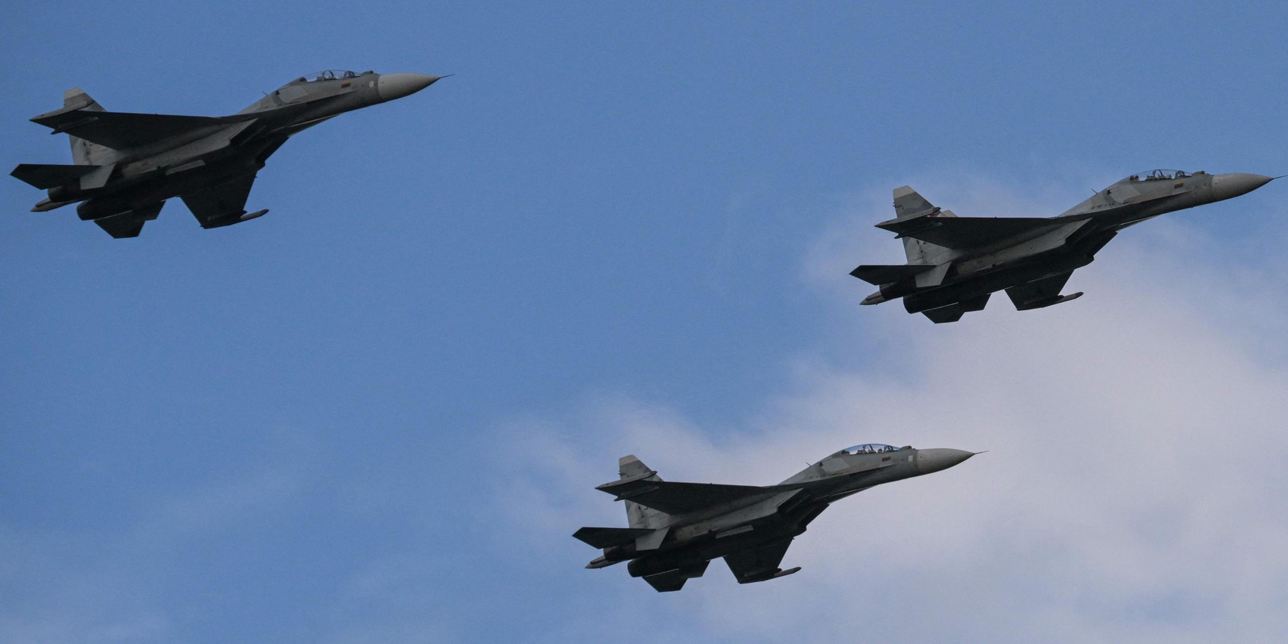 Vom russischen Hersteller gefertigte Mehrzweck-Kampfjets vom Typ Sukhoi Su-30MKV der venezolanischen Luftwaffe überfliegen eine Militärparade.