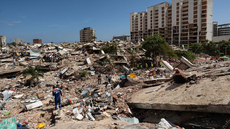 Menschen suchen in einem großen Trümmerfeld in La Guaira, Venezuela